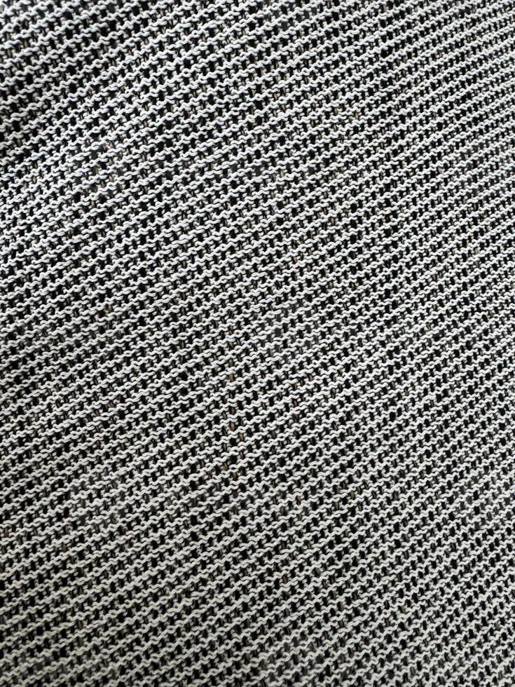 Textured gray fabric showing intricate woven patterns under natural light conditions photo