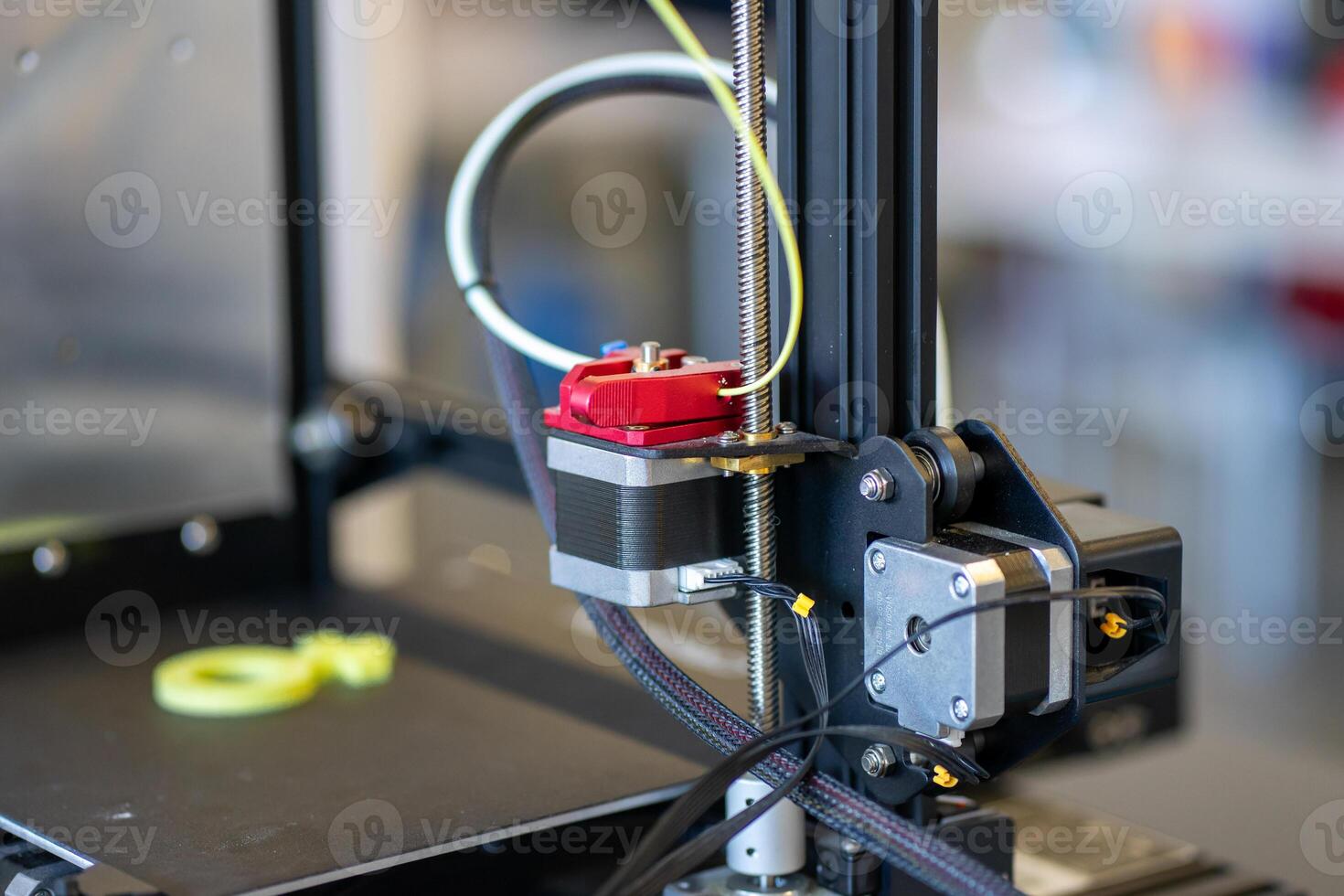 A small 3D printer that prints a green symbol out of plastic photo