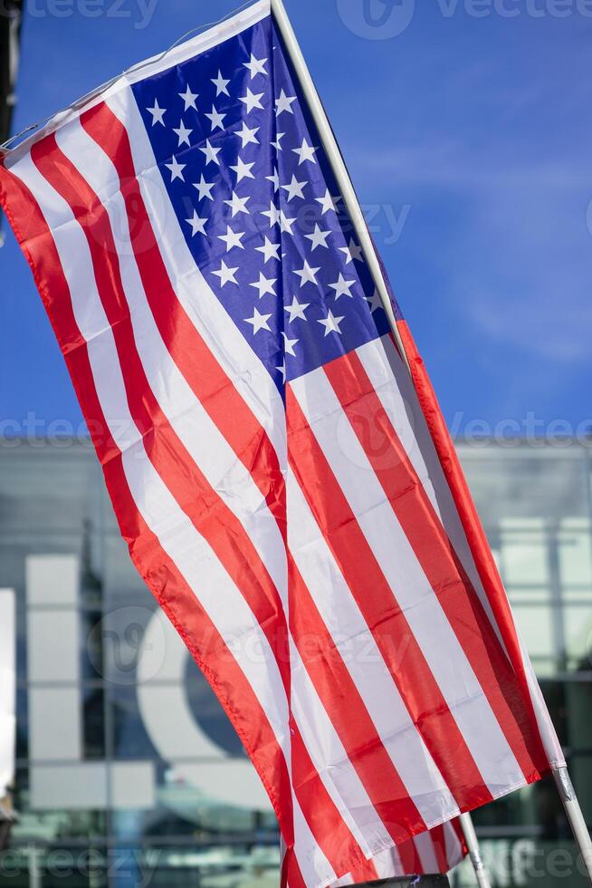 A small waving American flag against the background of a building at a parade photo