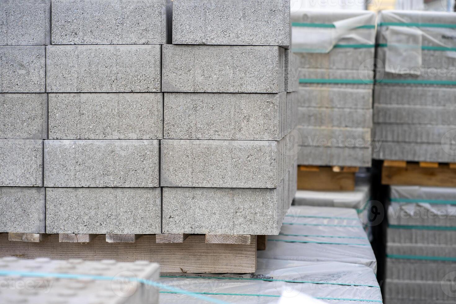 View of stacked gray paving slabs on a wooden pallet at a construction site photo