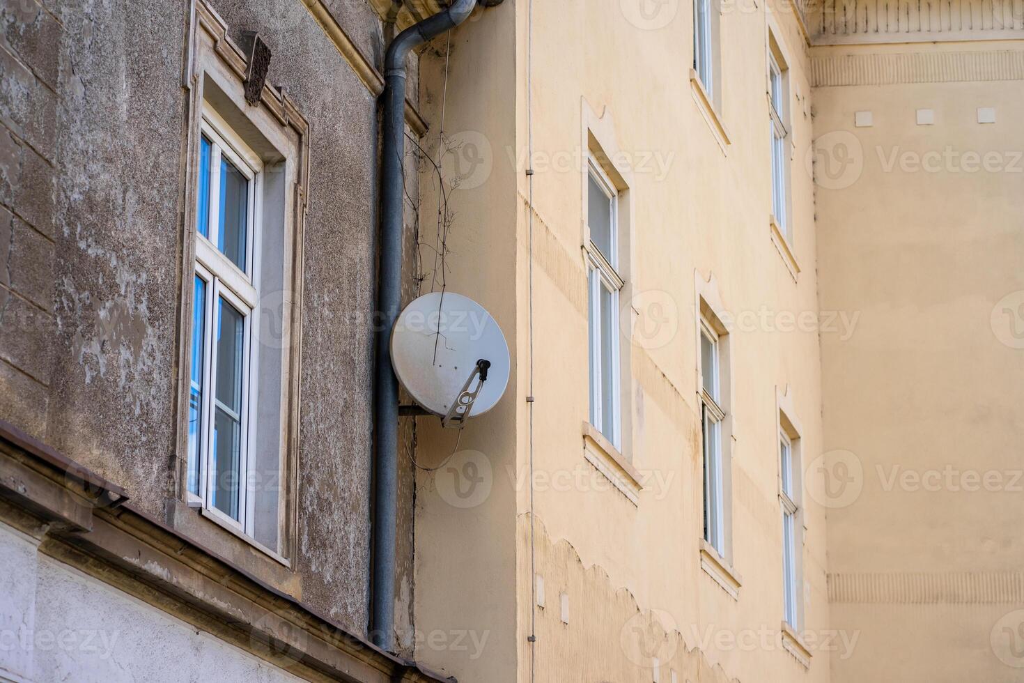 View of a satellite dish installed on the wall of a residential building photo