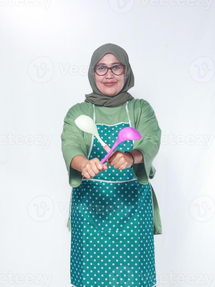 Smiling female chef holding ladles in a playful pose, ready to cook delicious meals photo