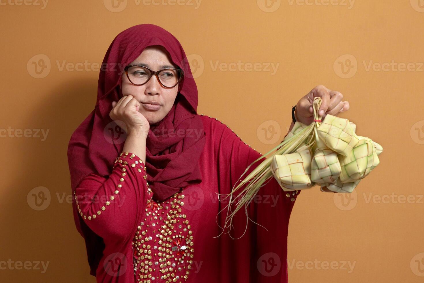 Muslim Woman Holding Ketupat with Bored Expression photo