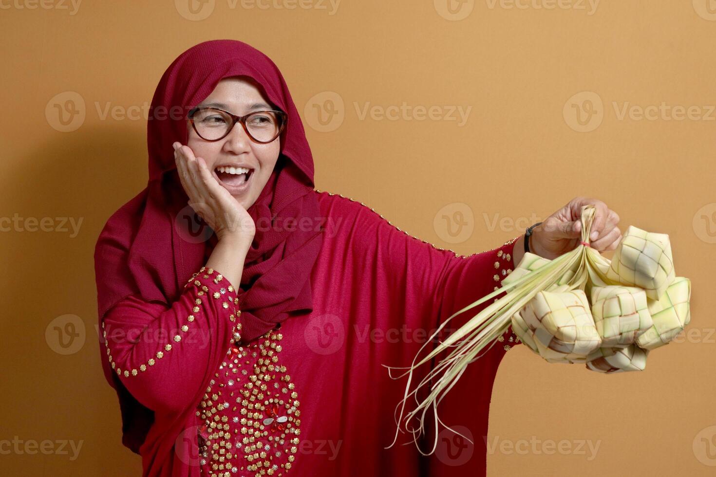Muslim Woman Holding Ketupat Celebrating Eid al Fitr Tradition photo
