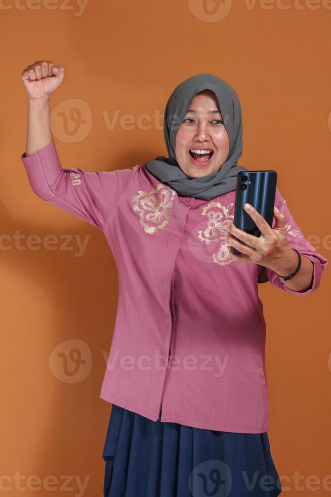 Joyful Muslim woman taking call selfie with excited expression, trending happy lifestyle and communication concept photo
