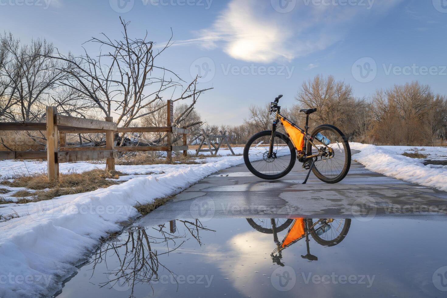 mountain bike on Poudre River Trail near Greeley in Colorado in winter scenery with puddle reflection photo