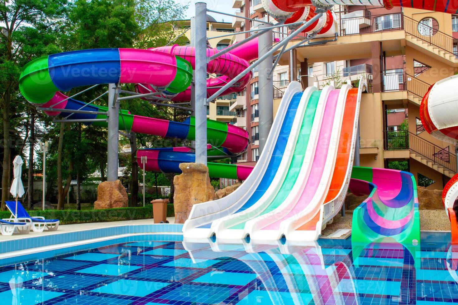 A colorful water slide in a pool with a colorful slide photo