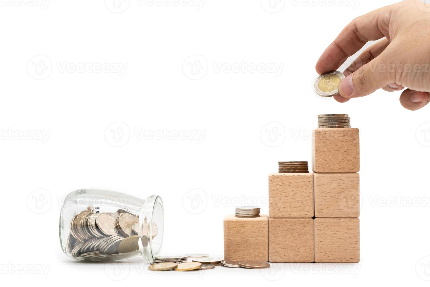 Wooden blocks with hand arranged coins stacked, Financial business investment, Growing money. Piles of coins standing on wooden steps isolated on white background. photo
