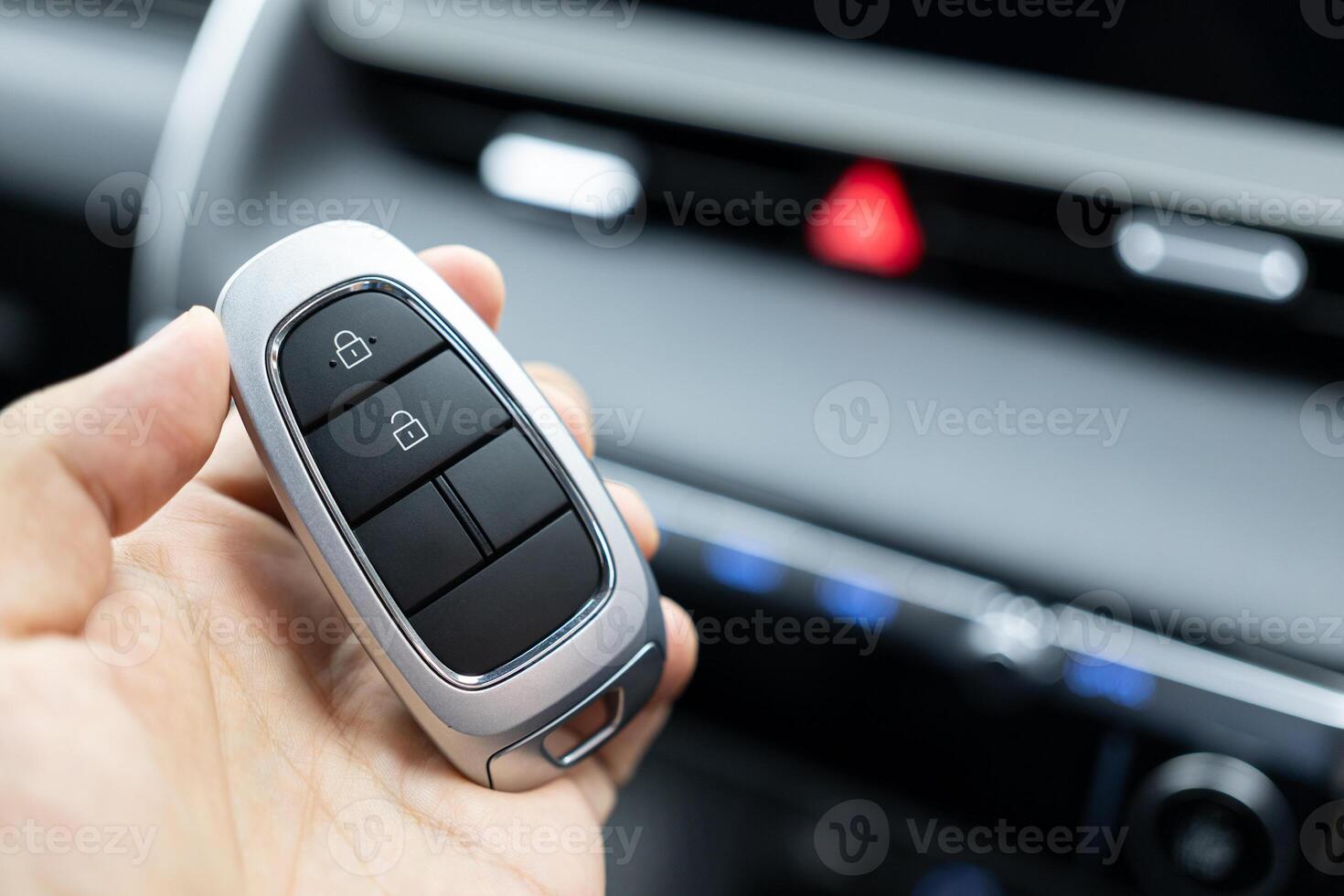 A man's hand holds the remote car key. smart key to lock or unlock doors of white car. Safety, travel and transportation concept. photo