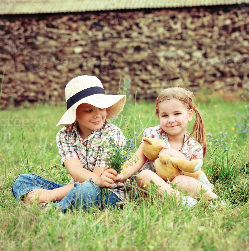 Little boy gives flowers to the little girl, country photo
