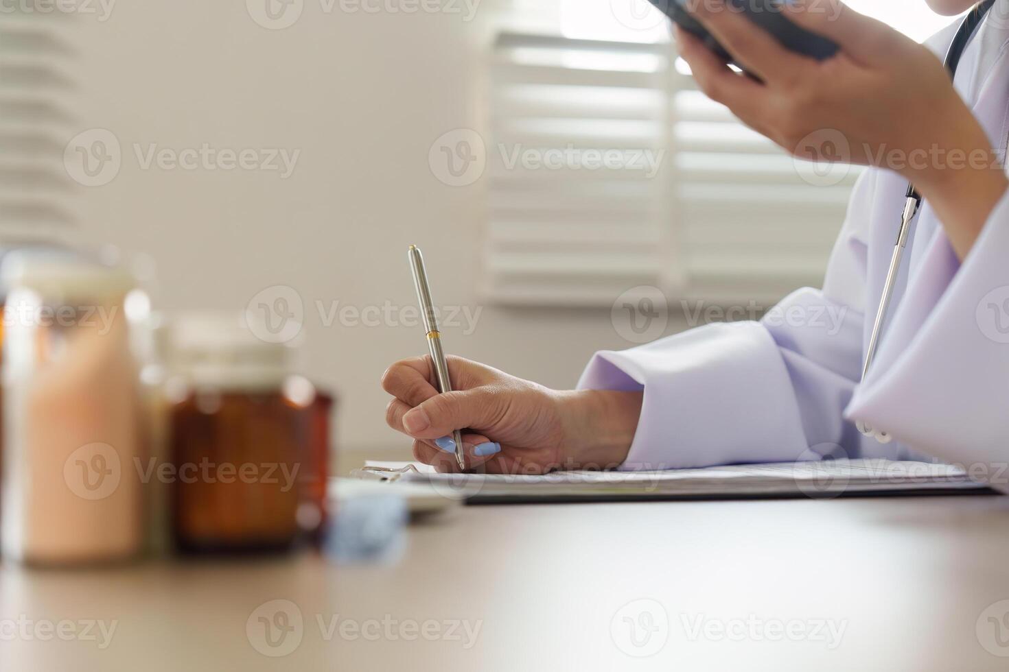Telemedicine and Note-Taking. A healthcare professional engages in remote consultation while making notes on medication assessment. photo