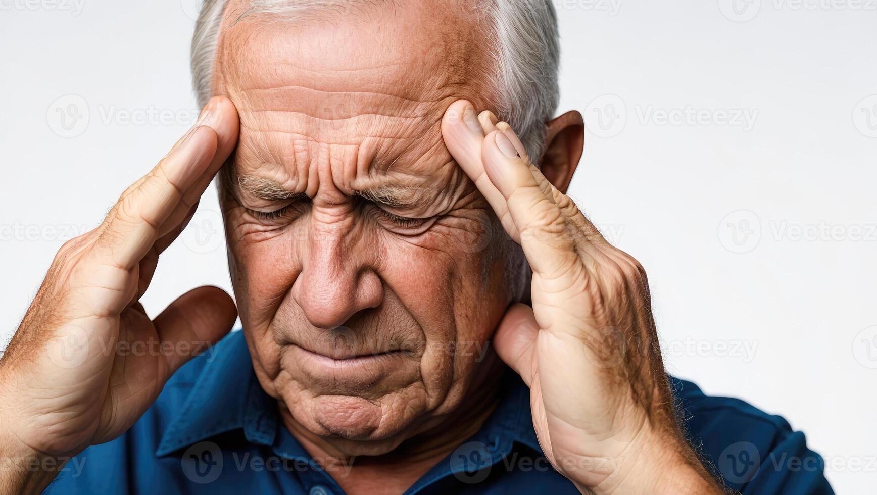 Elderly man experiencing headache while holding his temples in a neutral background photo