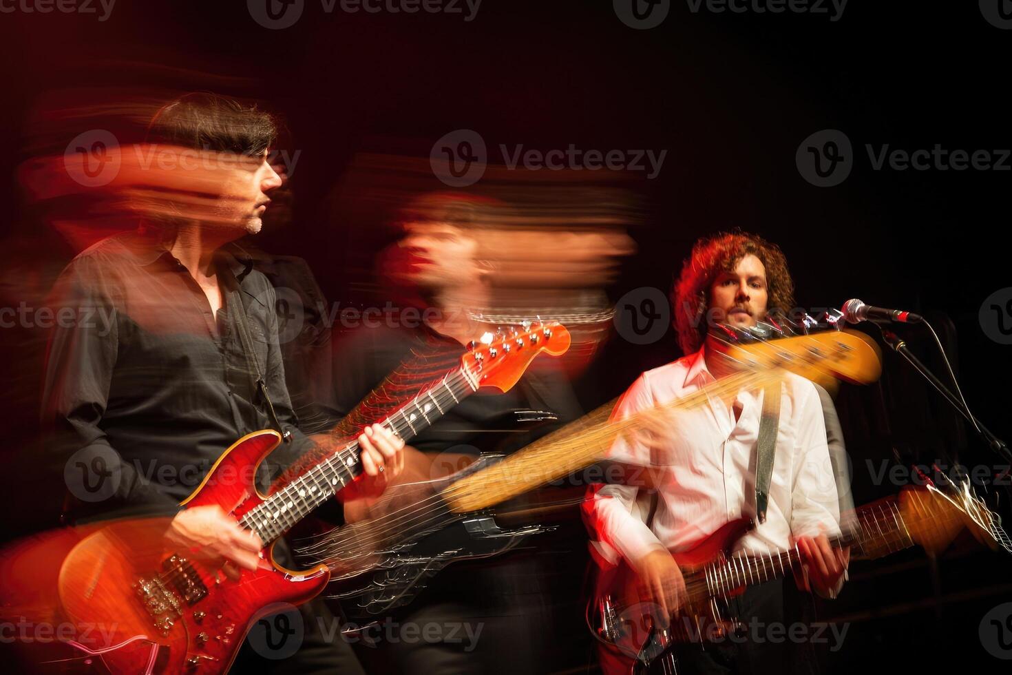 Vibrant rock band performing live with dynamic motion blur at nighttime concert event photo