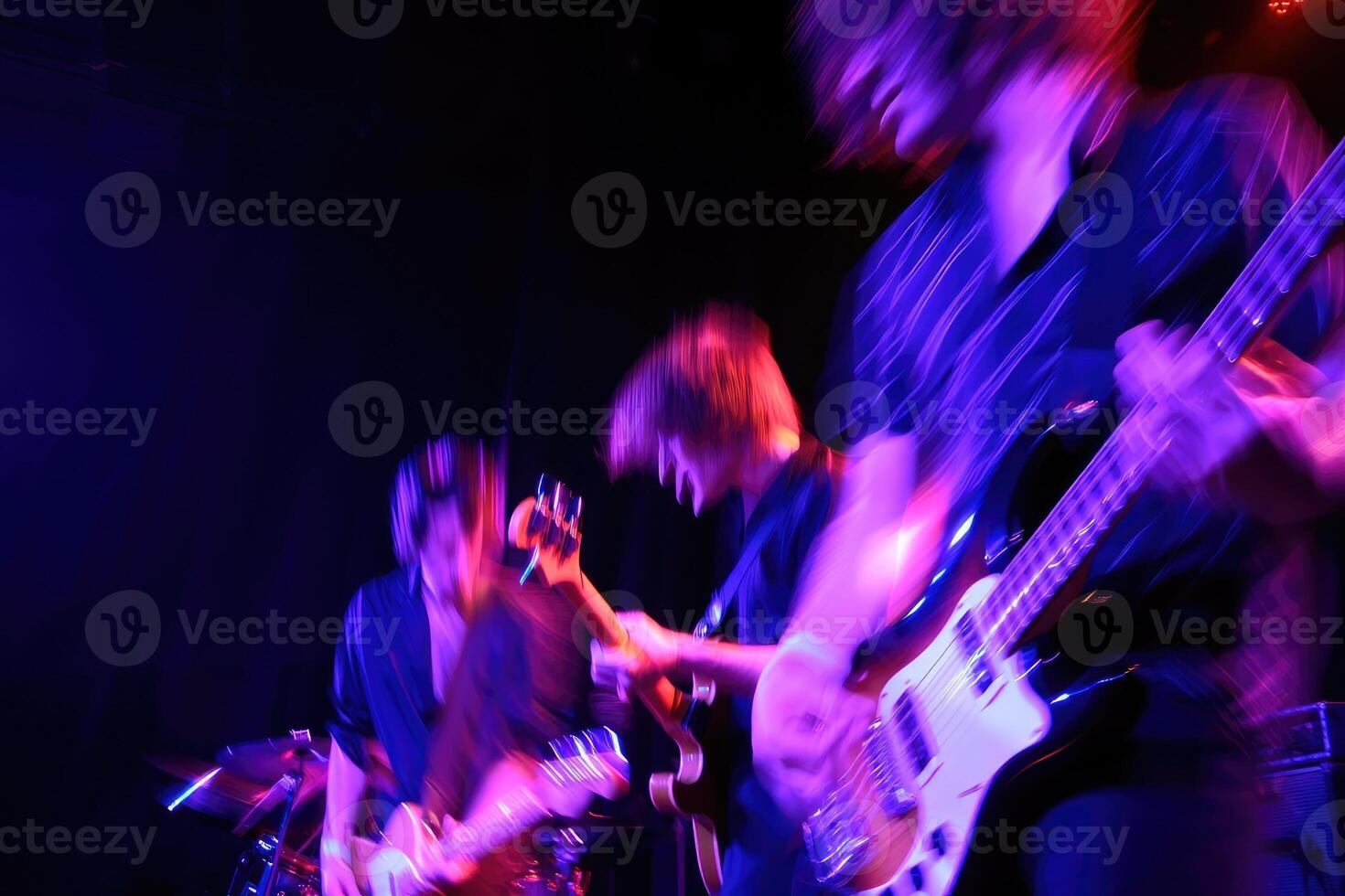 Energy filled live performance by a rock band at a dimly lit music venue in the city photo