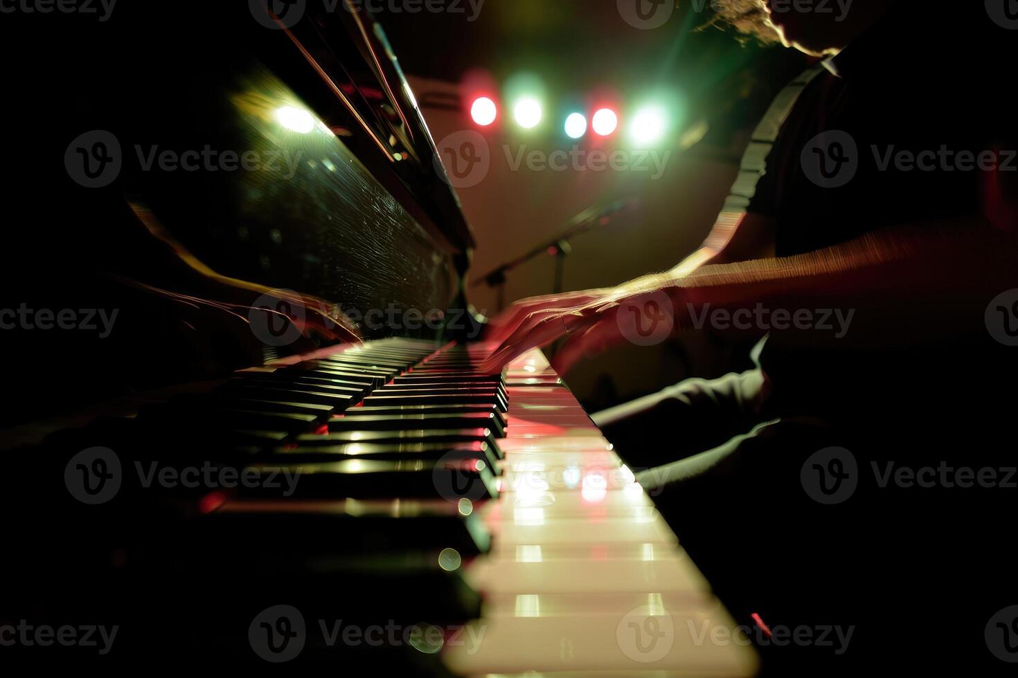 Pianist performing live with vibrant lights illuminating the stage at an evening concert photo
