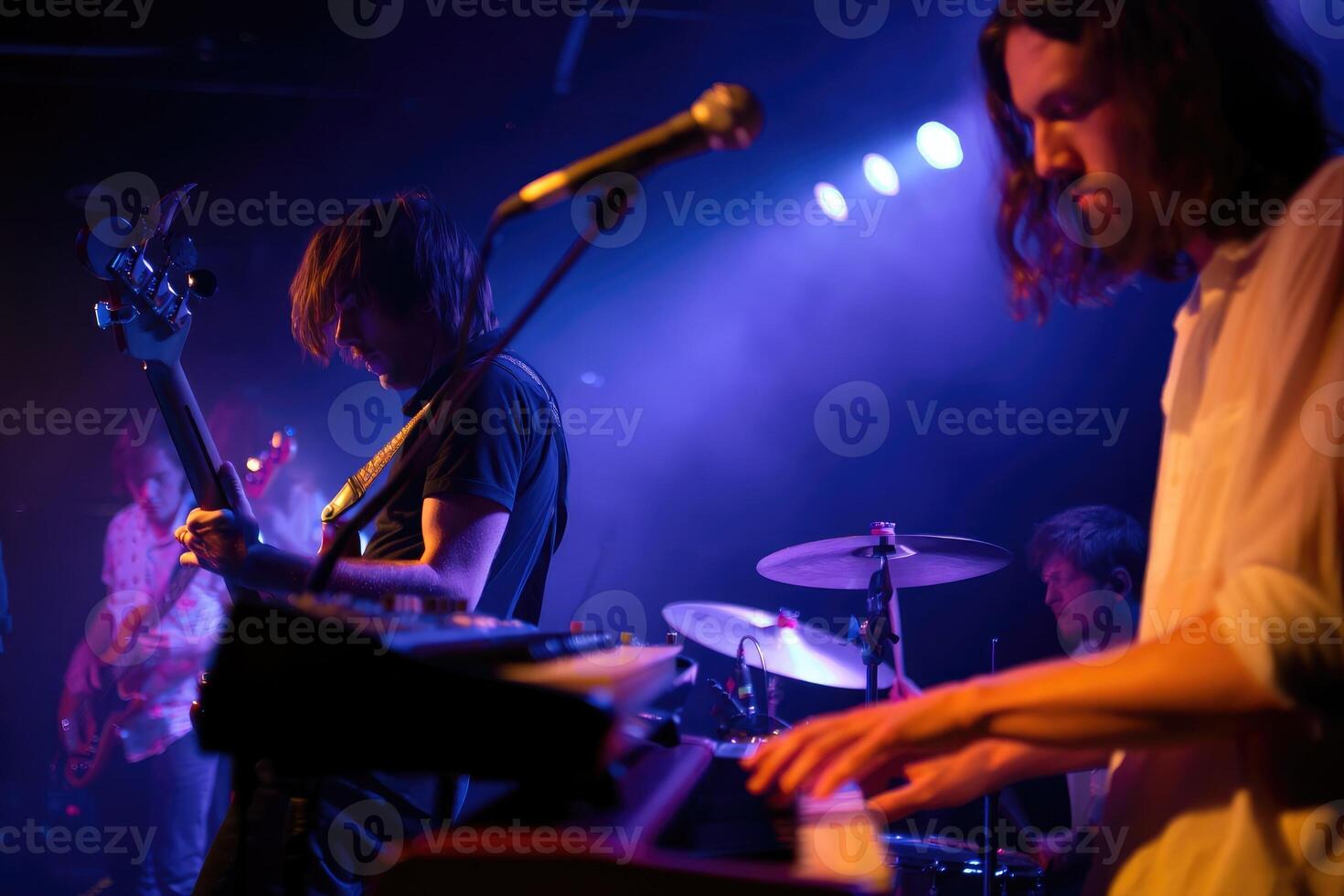 Musicians performing live on stage during an energetic concert at a music venue photo