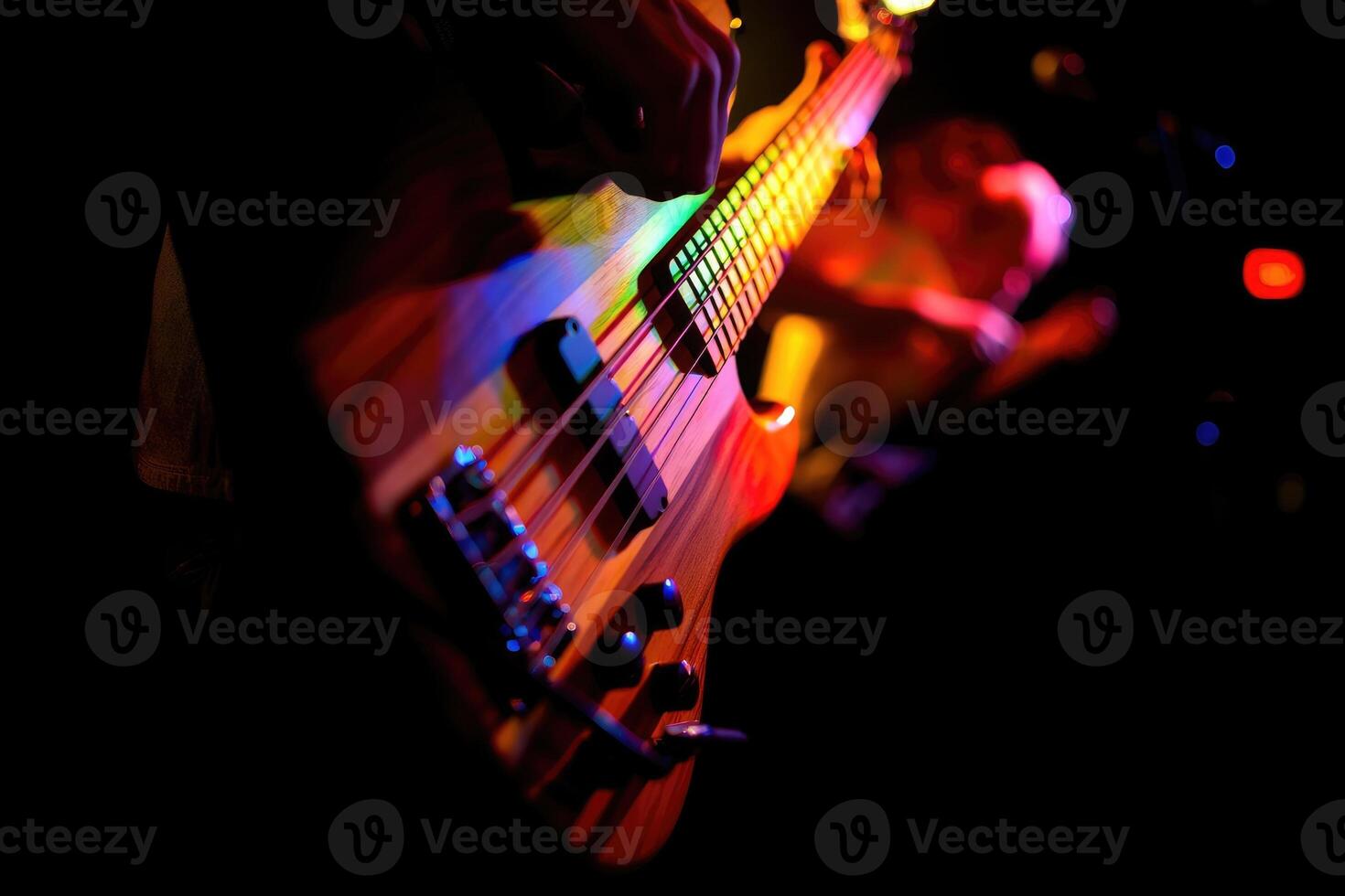 Close up of a colorful bass guitar during a live performance in a dimly lit venue photo