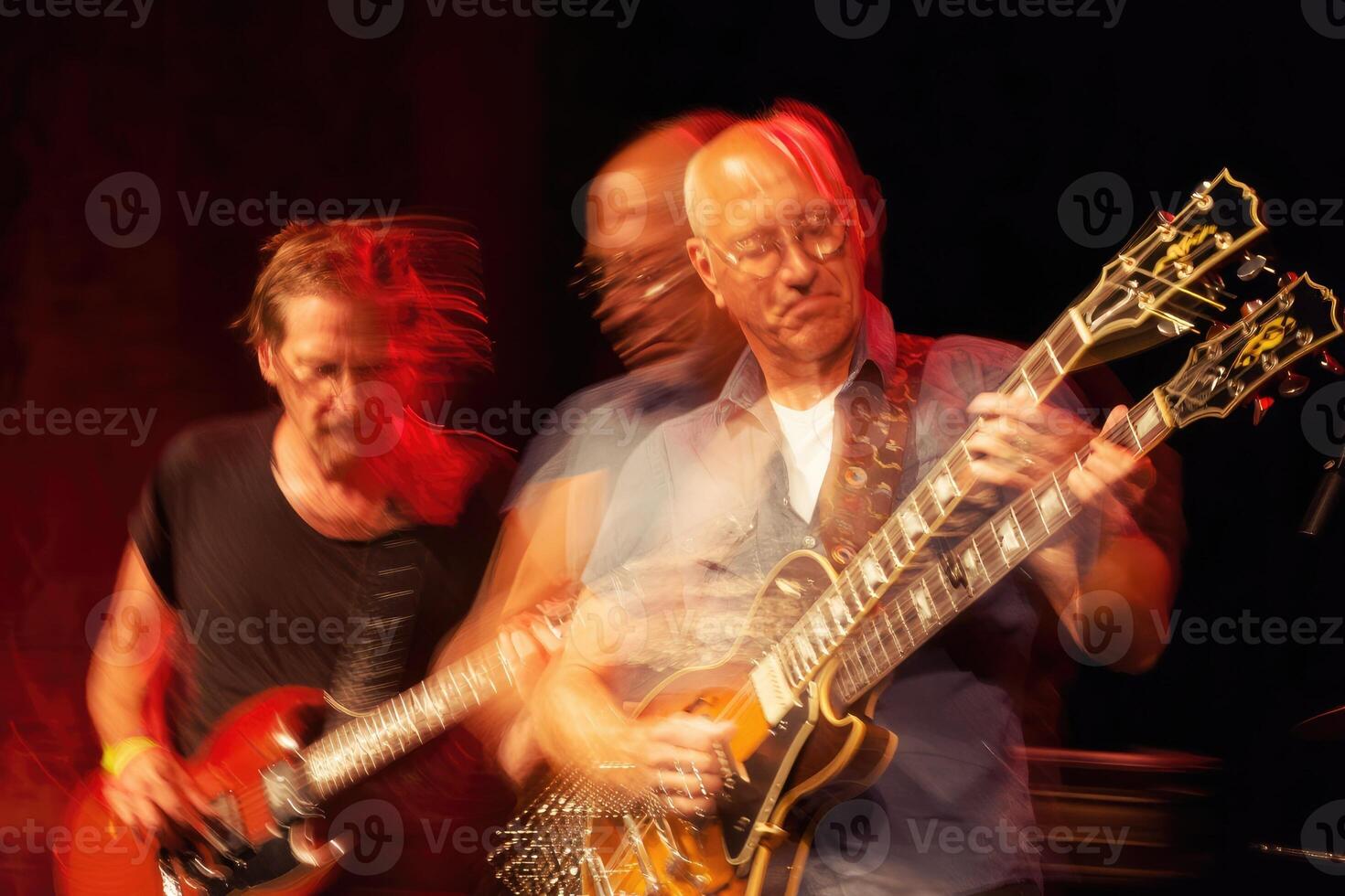 Dynamic performance of musicians at live concert with electric guitars in vibrant setting photo