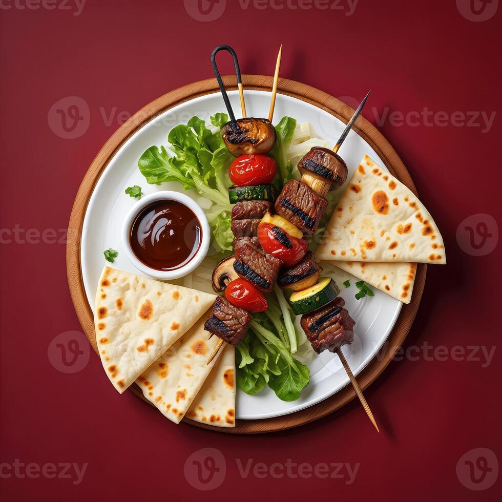 Delicious skewers of meat and vegetables served with fresh bread and sauce photo