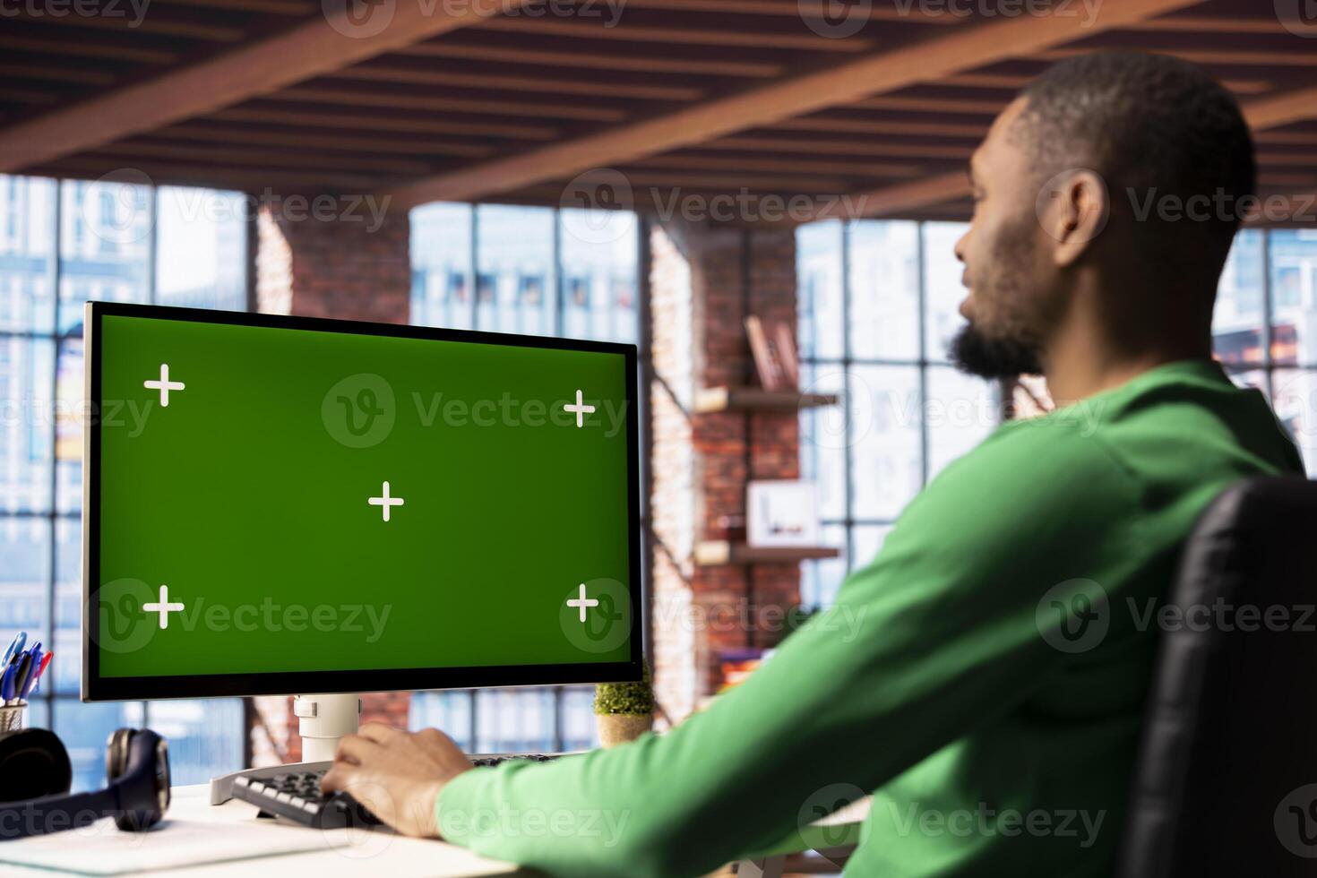 Man using isolated screen PC in home office to write emails. African american person typing on mockup computer keyboard, composing documents in order to deliver finalized project paperwork photo