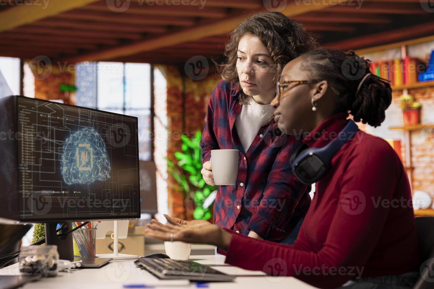 Programmer talking with coworker in AI startup office, building application together. Woman and colleague holding coffee mug in artificial intelligence software development agency doing brainstorming photo