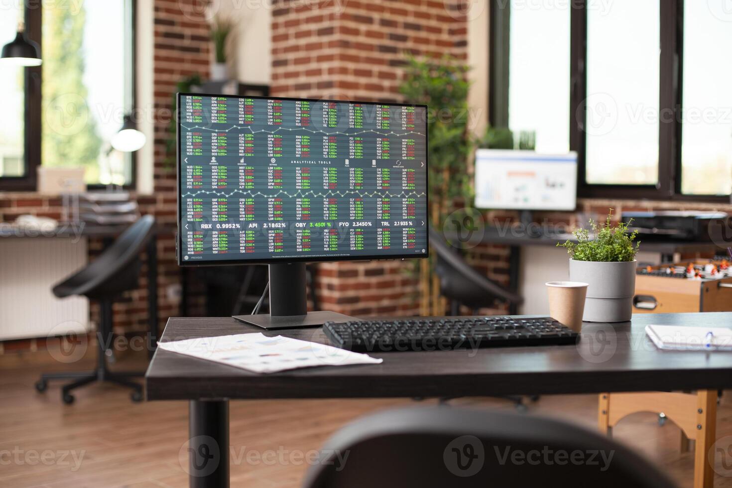 Digital display of financial stock data in vacant startup office focusing on market strategy research. Desktop monitor displaying business analytics tools, ready for use in brick wall room. photo