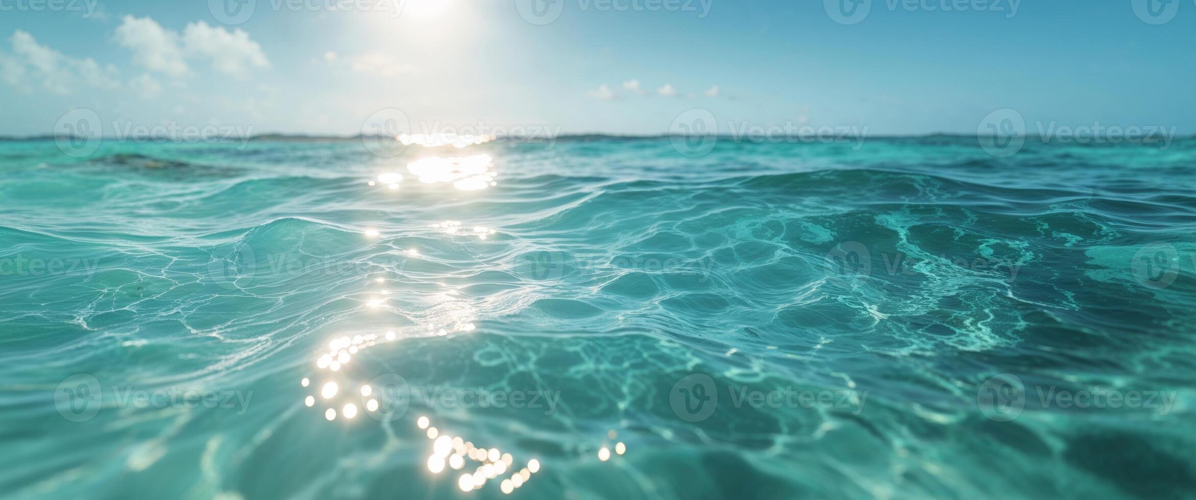 The sun shines over the ocean water photo