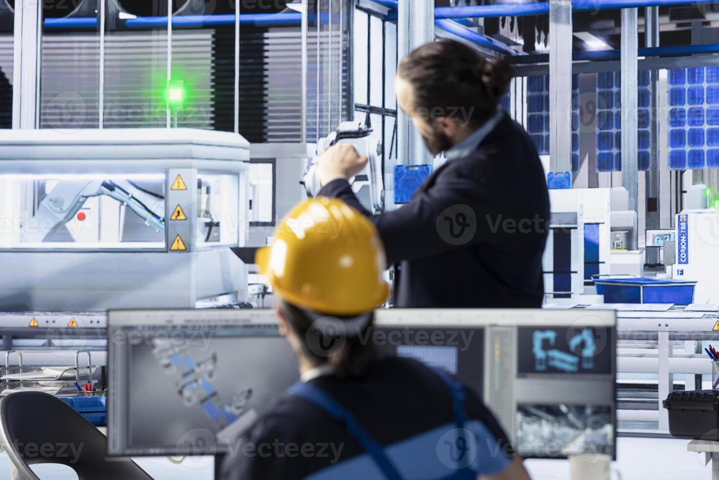 Photovoltaics factory technicians using computer to optimize production flow. Sustainable energy solar panels plant employees tracking software to monitor manufacturing process photo