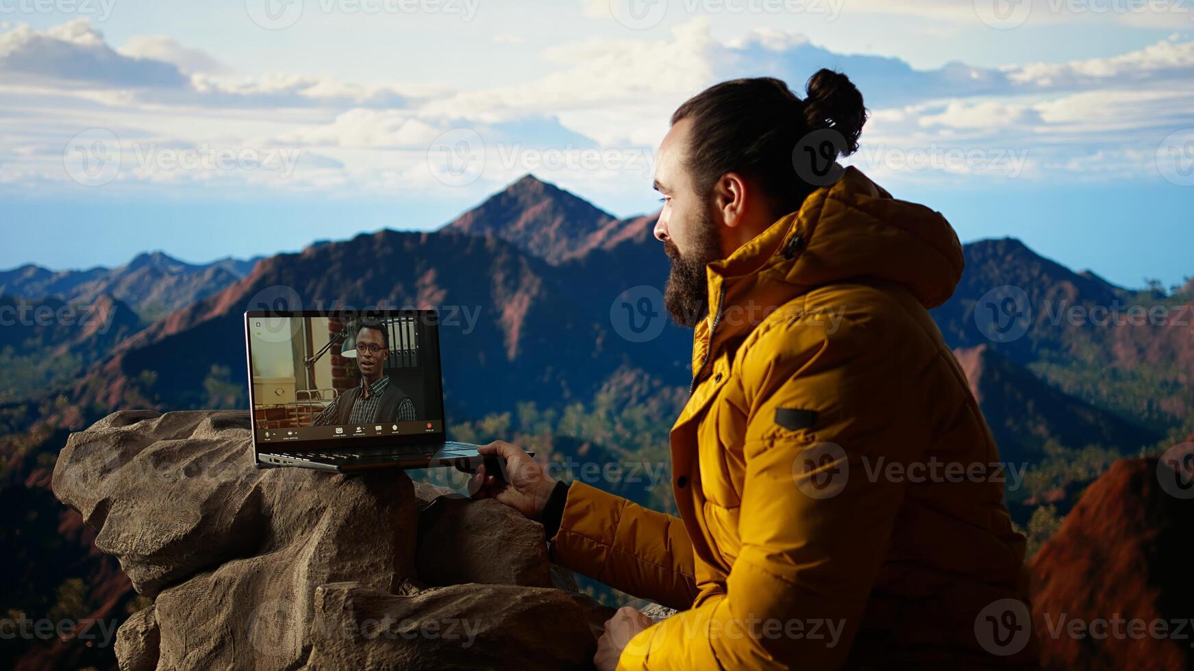 Workaholic explorer meeting with colleagues on online call, enjoying a strong signal high speed internet on top of the mountain. Young hiker CEO with dependency. Camera A. photo