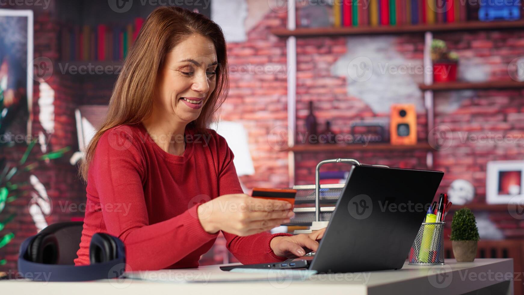 Relaxed woman entering card numbers to verify the balance before paying online, e commerce on webpages from the home desk. Person making web transactions and transferring money. Camera A. photo