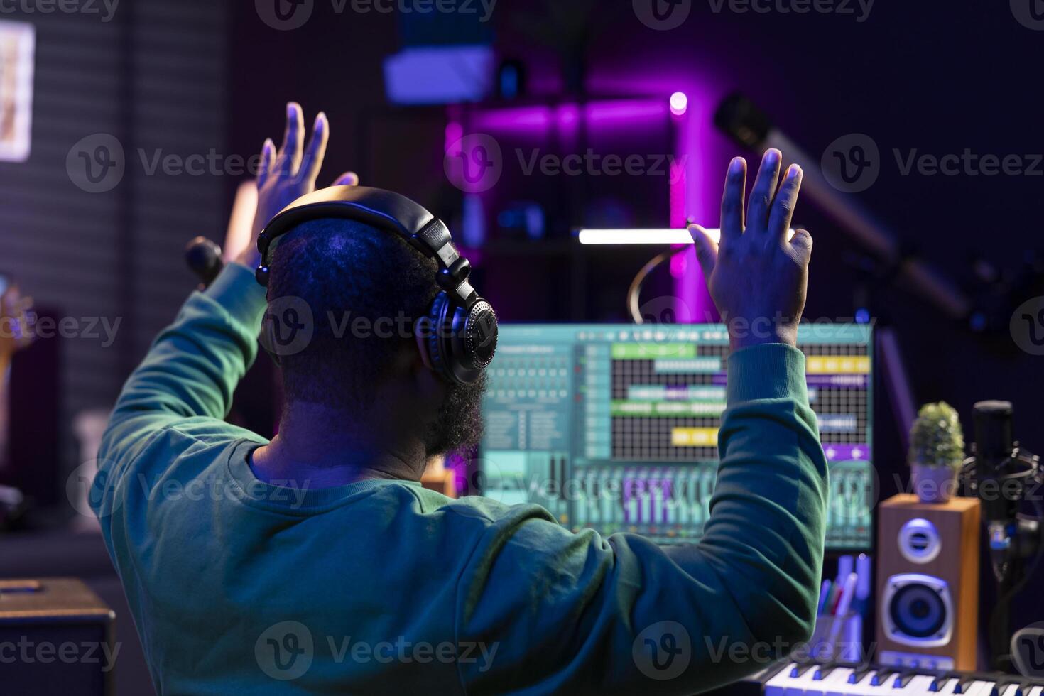 African american sound designer counting down before he starts the recording session, working with mixing console and software for editing in post production. Producer making music in home studio. photo