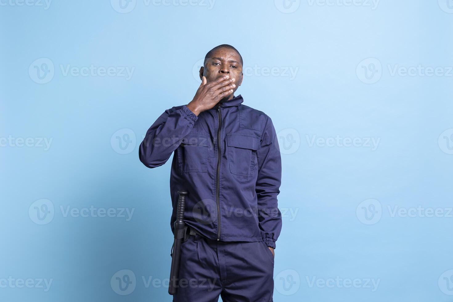 African american security officer yawning after a long night shift, working on protecting a public property. Safety agent feeling sleepy and overworked, exhausting occupation. photo
