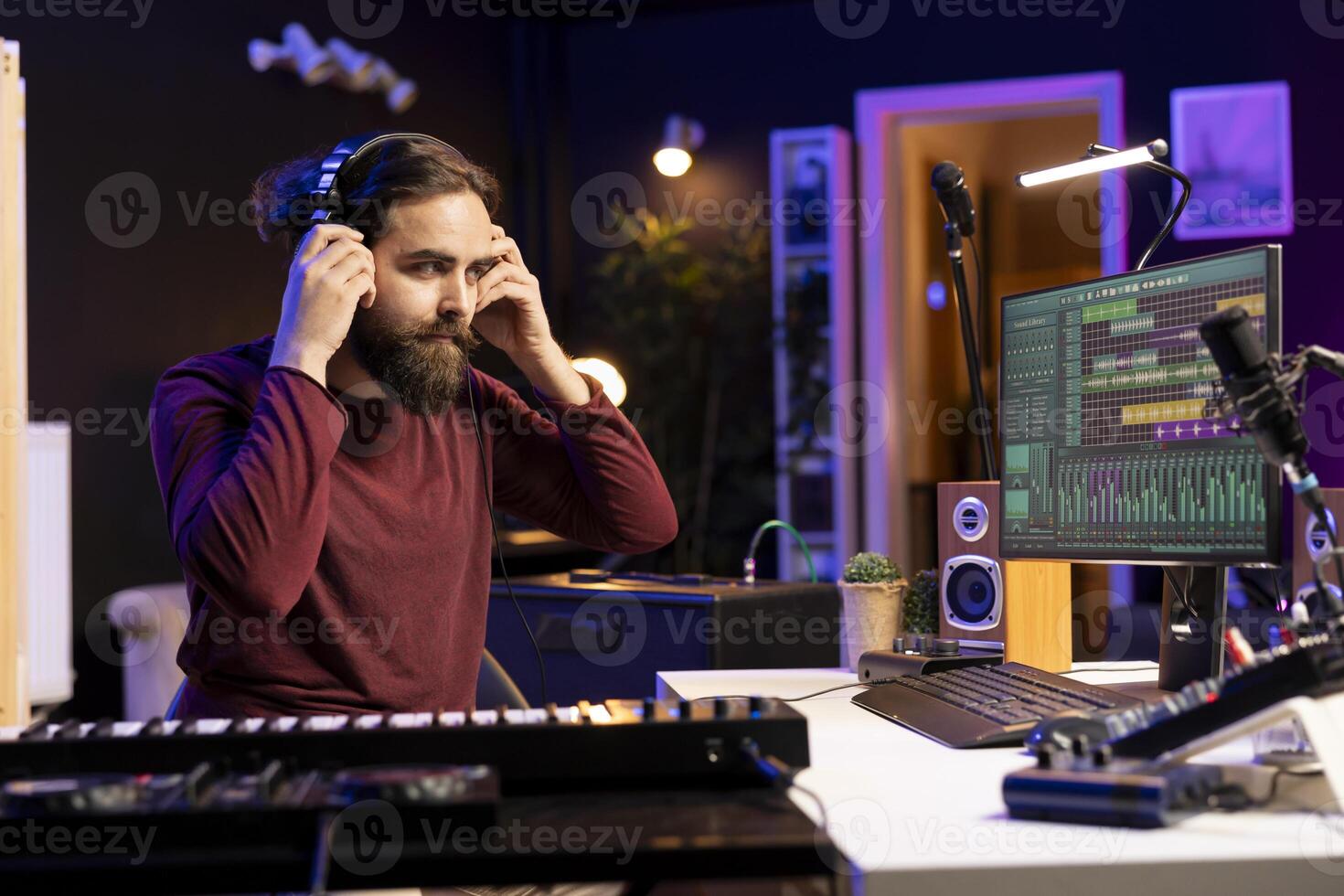 Audio engineer prepares recording tunes on daw software interface, working in music industry post production. Musician mixing and mastering songs, using headphones and soundboard. photo