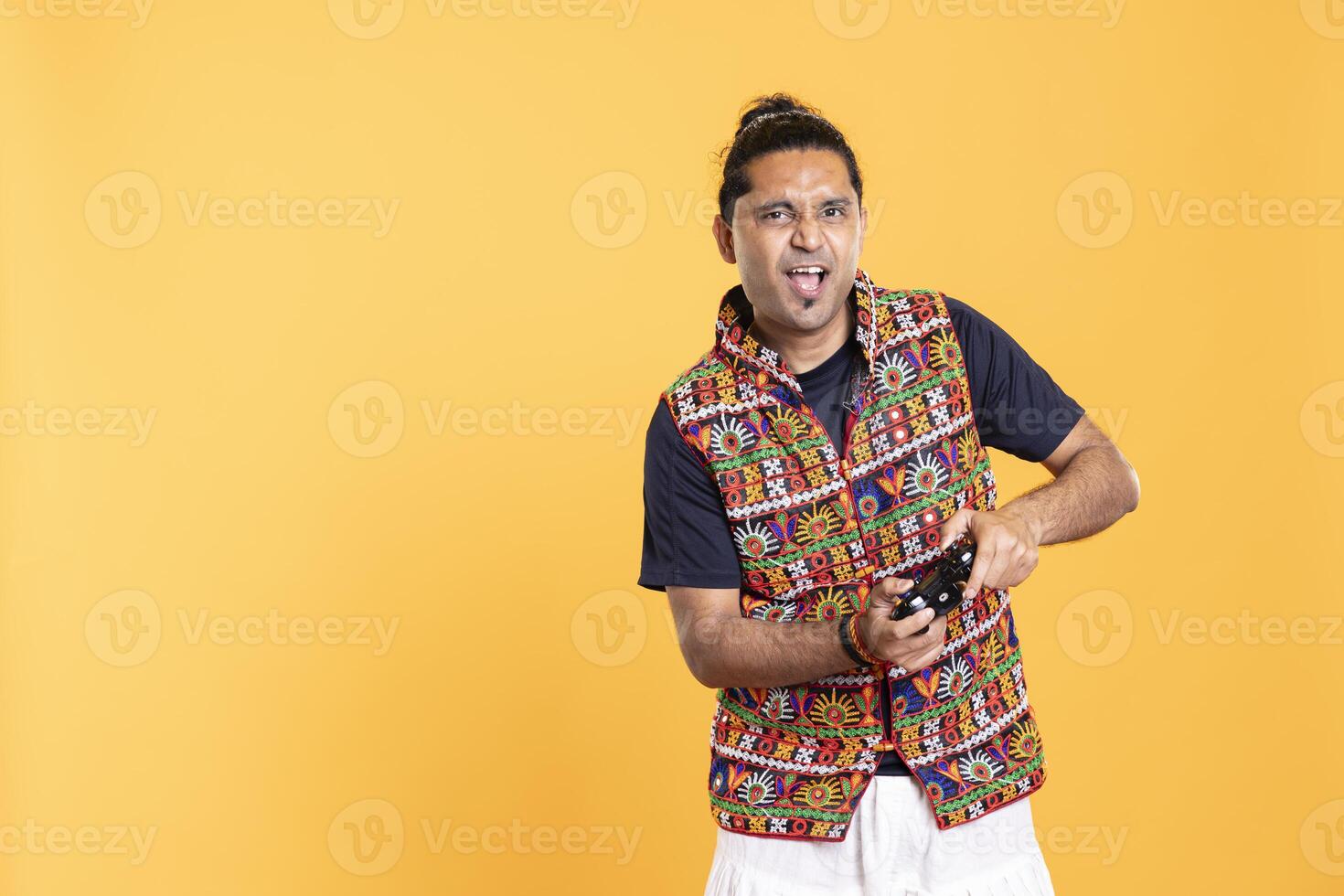 Cheerful man playing videogames with controller, studio background. Portrait of gamer smiling, having fun by participating in PvP online multiplayer game using console system photo