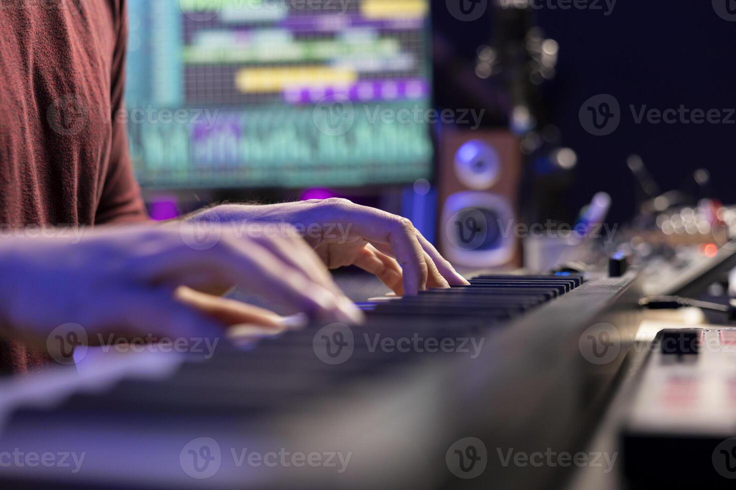 Music producer playing tunes on electronic midi controller, composing songs to use with mixing and mastering techniques. Singer plays electronic piano notes to create soundtracks. Close up. photo
