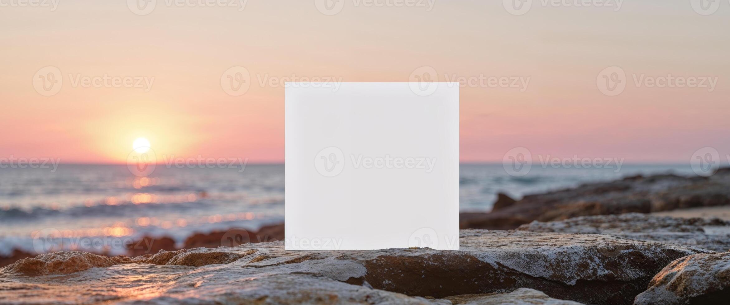 A blank white box sitting on a rock in front of the ocean photo