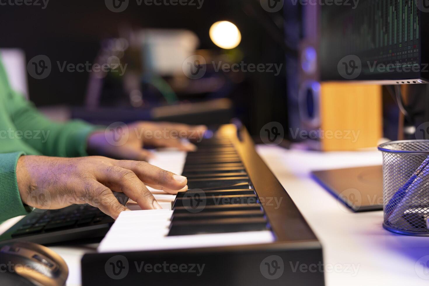 Songwriter performing a song on electronic piano keyboard, editing the audio files in post production. Artist technician mixing and mastering tracks on stereo console, musical notes. Close up. photo