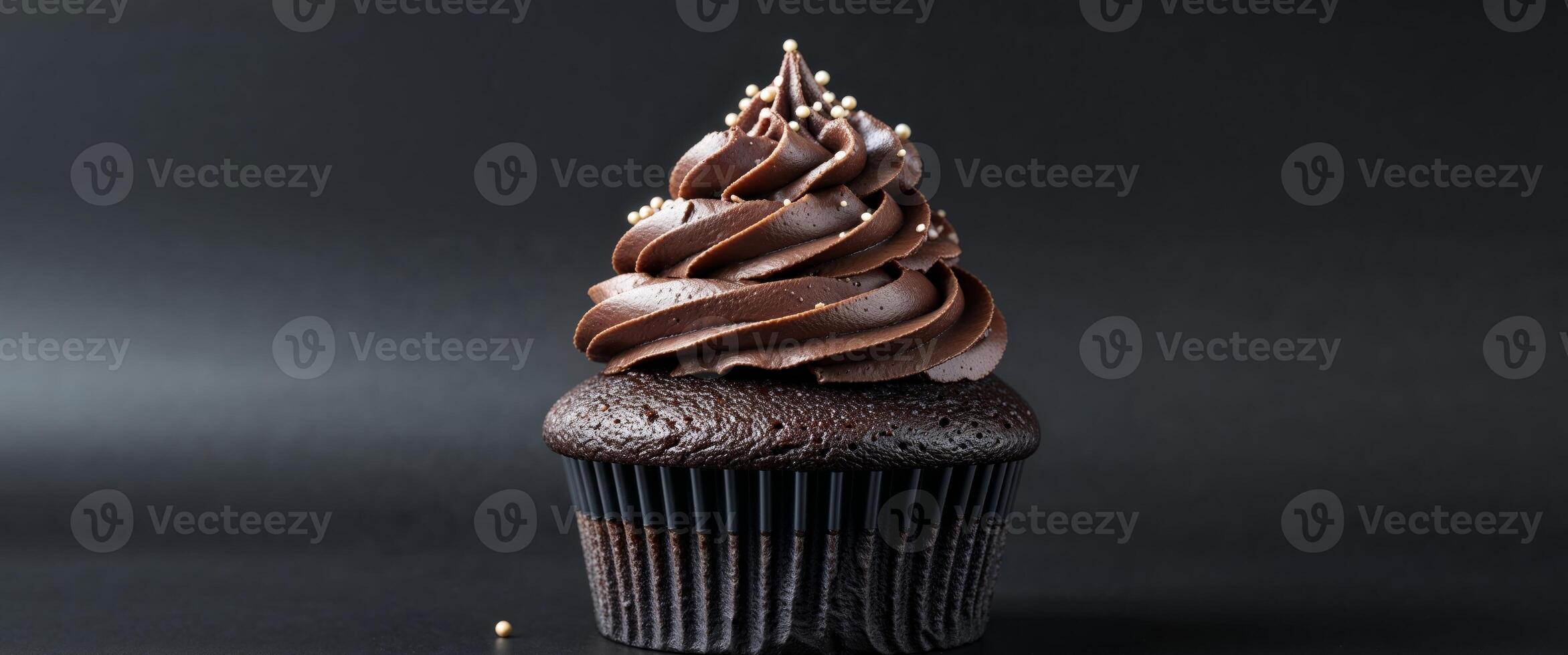 A chocolate cupcake with a frosting topping photo