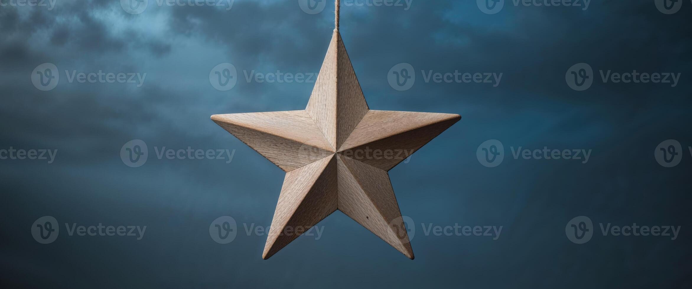 A wooden star hanging from a string photo