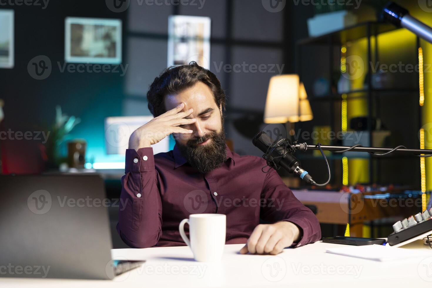 Influencer in home studio doing live broadcast for online streaming platforms, talking with fans, sharing embarrassing story. Blushing media star feeling flustered while telling viewers about himself photo