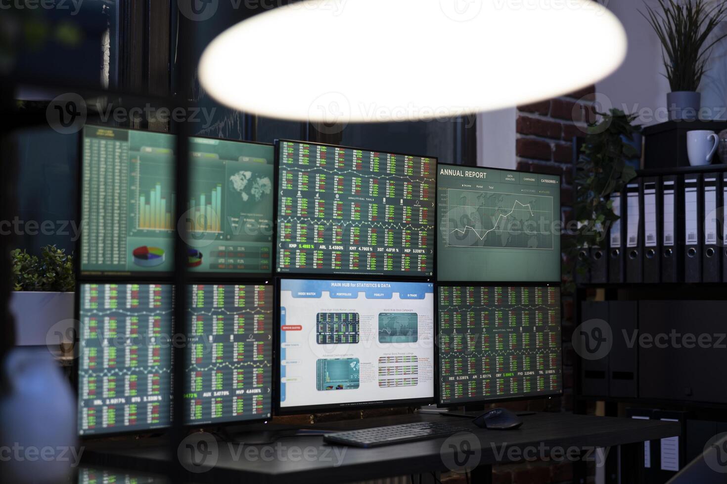 Empty desk with multi screens displaying forex charts, ready for the team to begin trading in modern, tech savvy workplace. Desktop monitors showing financial data, prepared for night shift workers photo