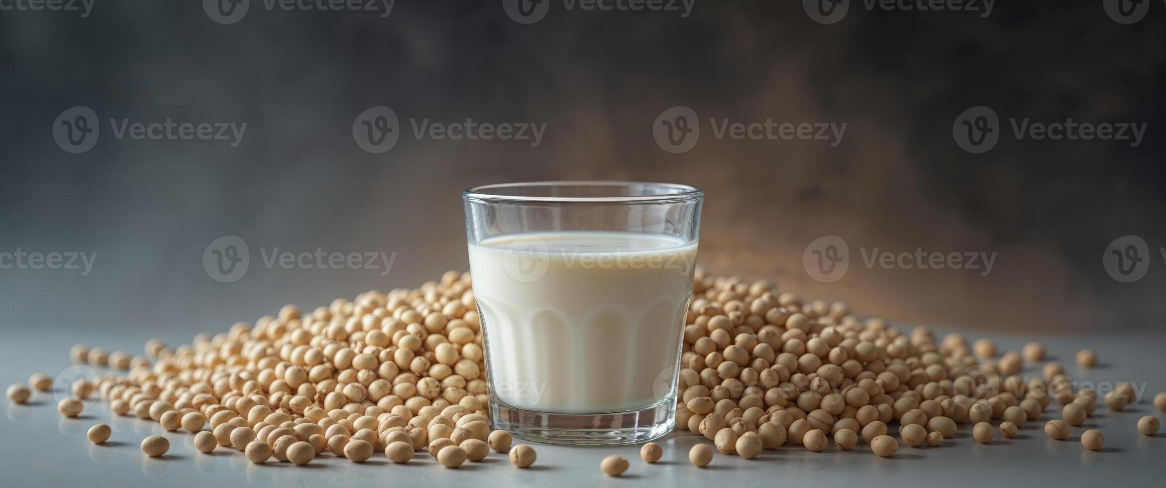 Soy milk in glass with soy beans on dark background photo