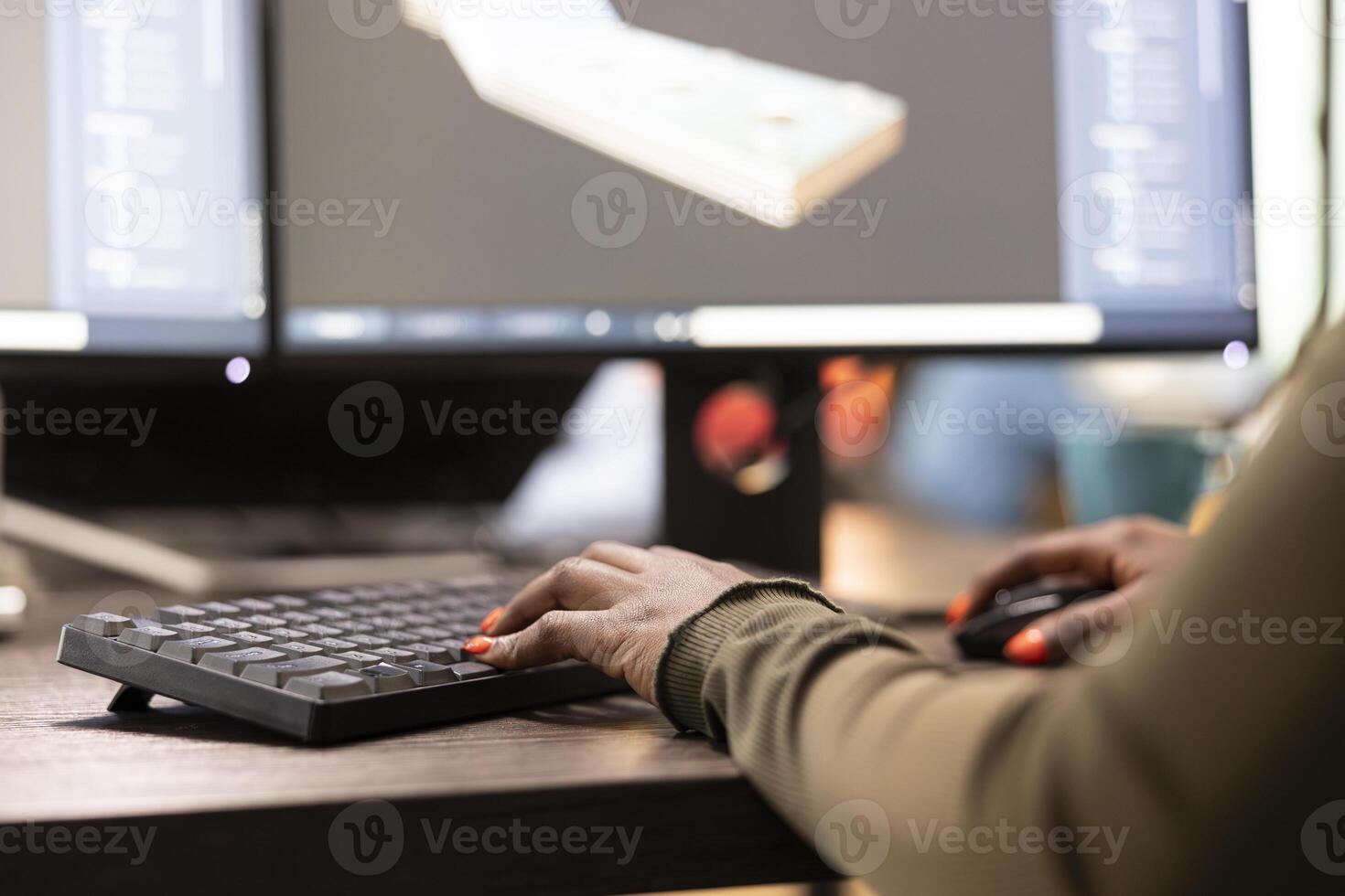 Digital artist refining geometry and sketching machinery tools using advanced design software on computer. Closeup of an african american 3D modeler improving project geometry. photo