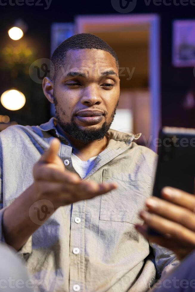 Black guy attending a virtual workshop lecture via online conference, participating at the discussion in his home. Young person joining conference meeting, interactive learning. photo
