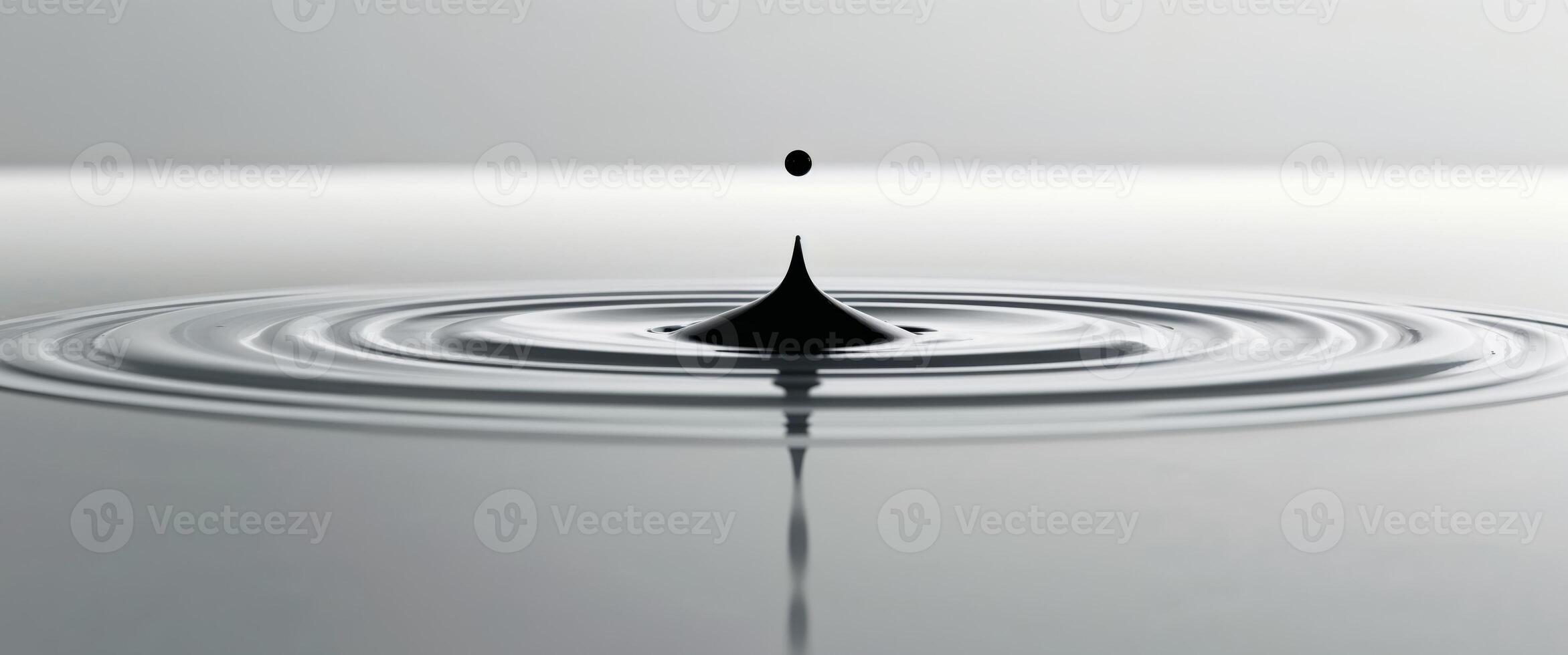 A drop of water is falling into a pool of water photo