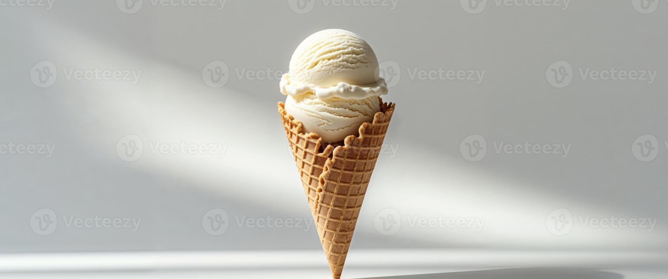 A single scoop of vanilla ice cream in a crispy waffle cone photo