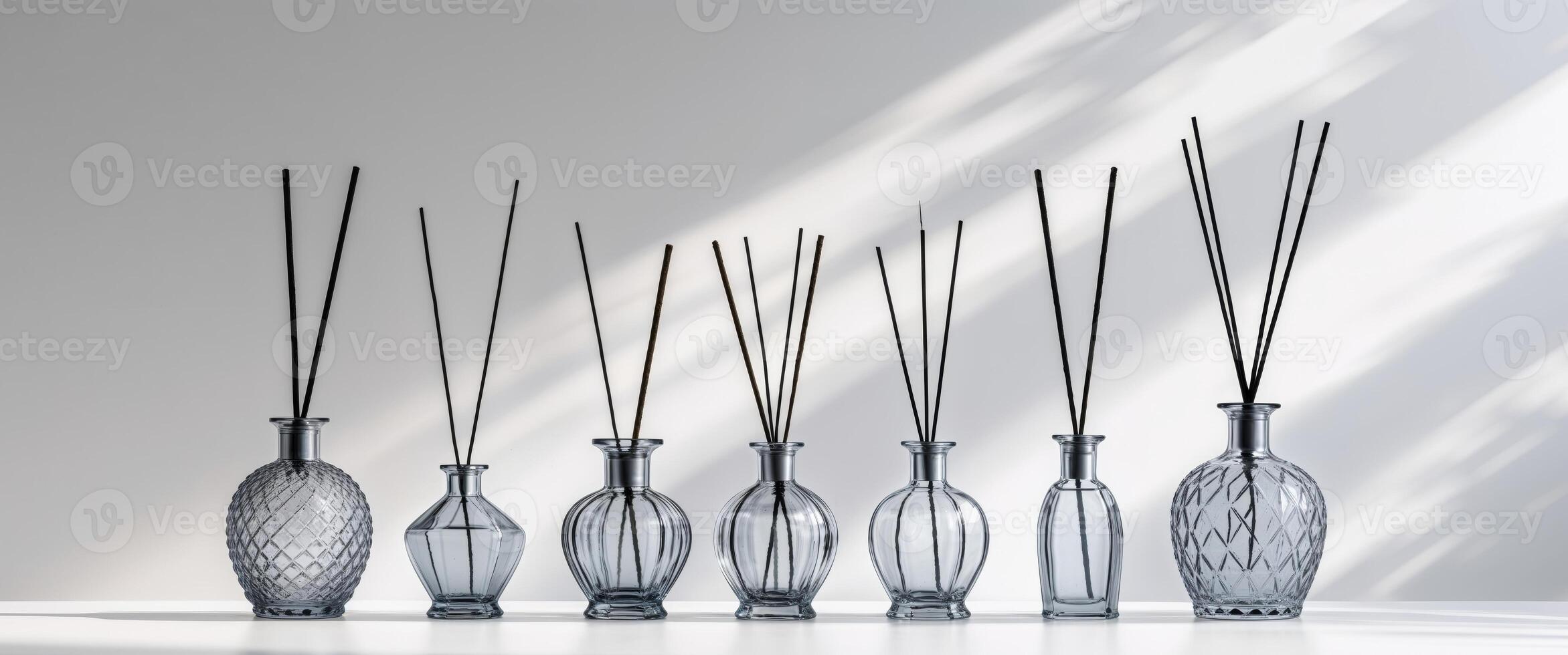 Six vases with sticks in them on a white surface photo