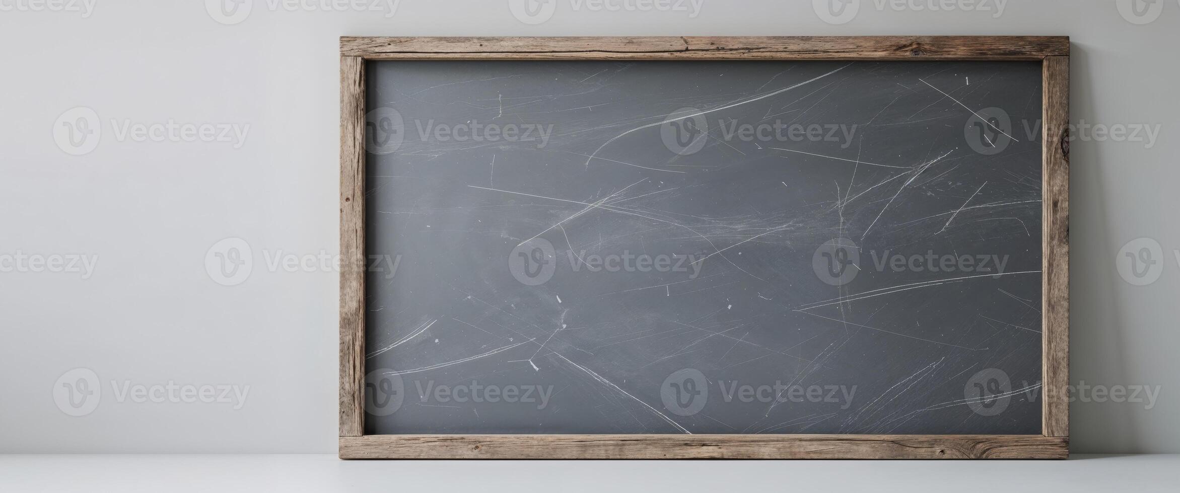 A chalk board with a wooden frame on a white wall photo
