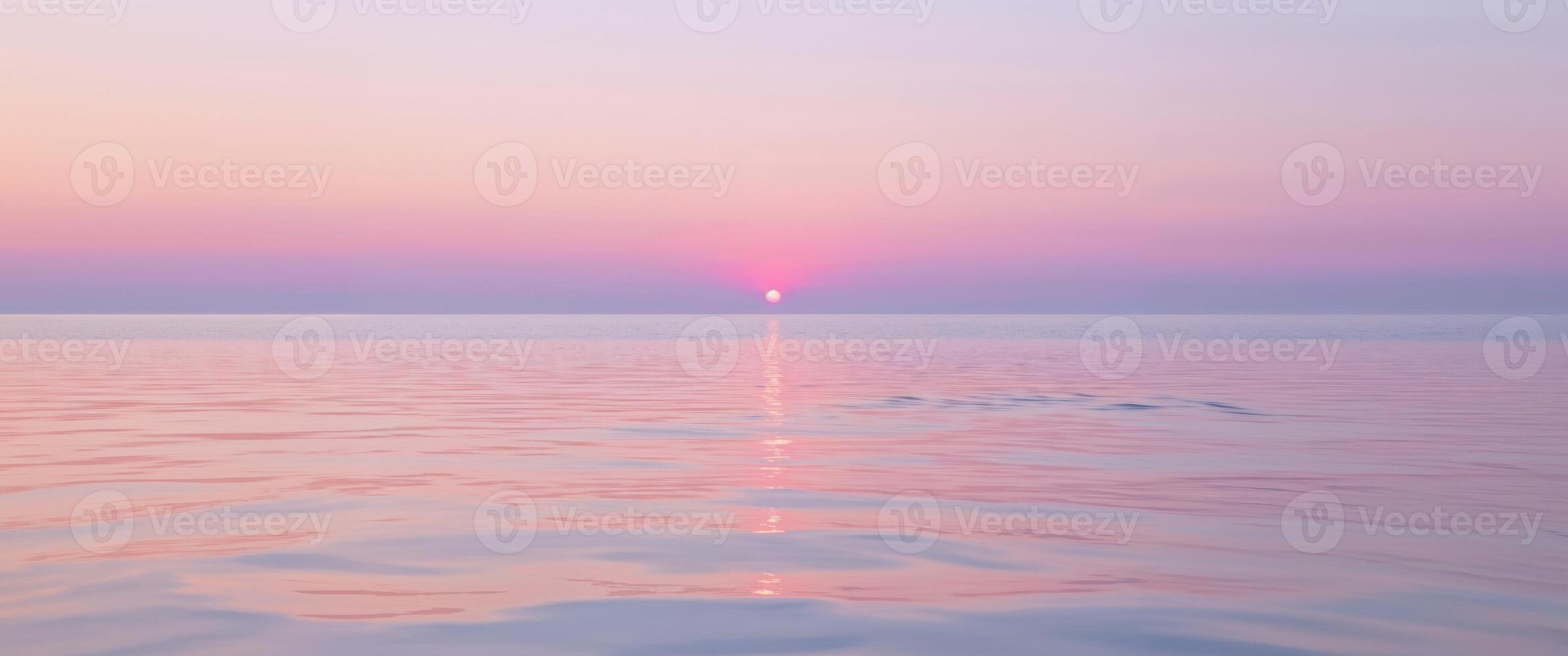 A sunset over the ocean with a pink sky photo