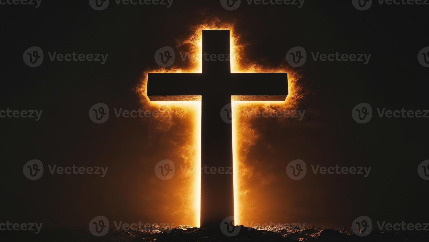 Cross silhouette illuminated by golden light in a dark setting. photo